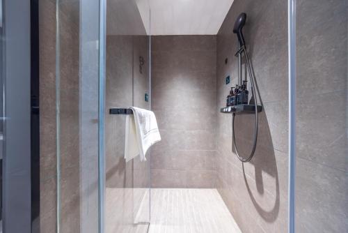 a shower with a glass door in a bathroom at Atour Hotel Nanjing South Railway Station North Square in Jiangning