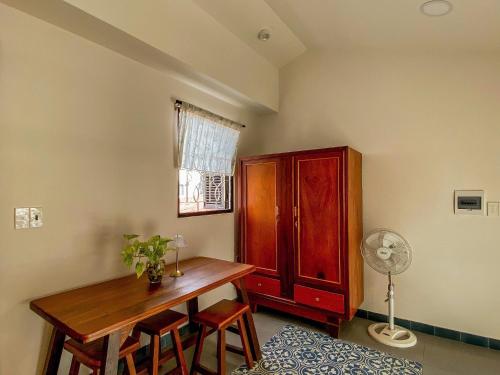 a room with a table and a wooden cabinet at DƯỚI TÁN CÂY homestay in Tây Ninh