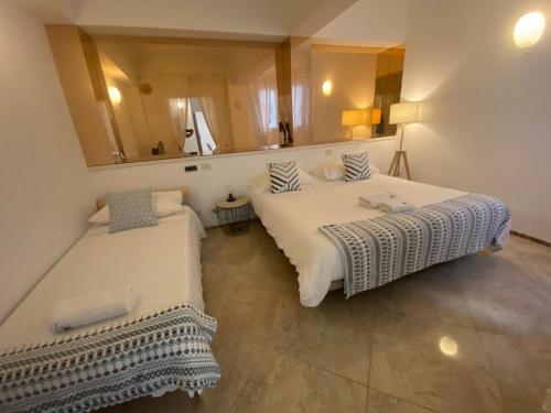 deux lits dans une chambre avec un miroir dans l'établissement Luxury Beachfront Penthouse with Stunning Views, à Las Palmas de Gran Canaria