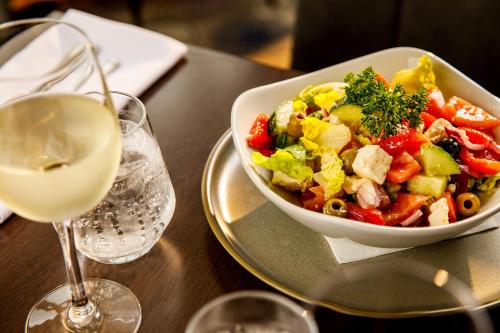 a bowl of salad on a table with a glass of wine at Sunday London Staines-upon-Thames Heathrow T5 in Staines