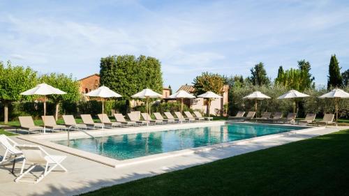 a swimming pool with lounge chairs and umbrellas at Borgo San Vincenzo in Montepulciano