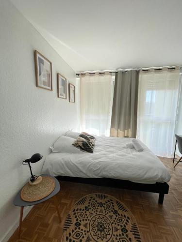 une chambre avec un lit, une table et une fenêtre dans l'établissement L'Émeraude Gare Un Séjour à Part, à Metz