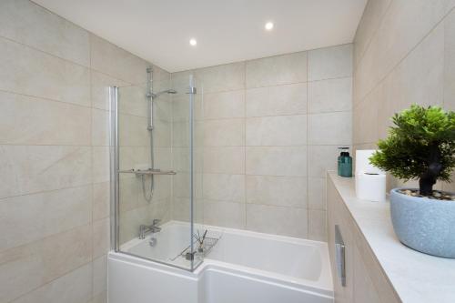 a bathroom with a shower and a white tub at Harrogate Haven by Luxus in Harrogate
