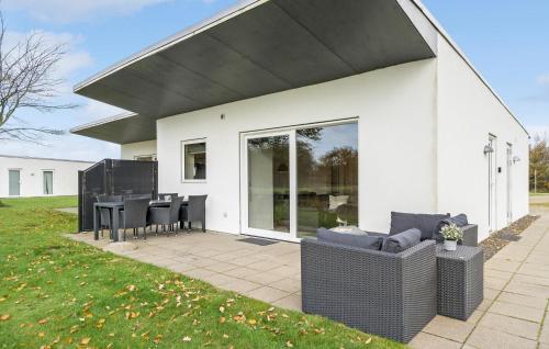 HeeにあるHoliday Home Dyrefolden Ringkøbing Denmのパティオ(テーブル、椅子付)が備わるホワイトハウスです。