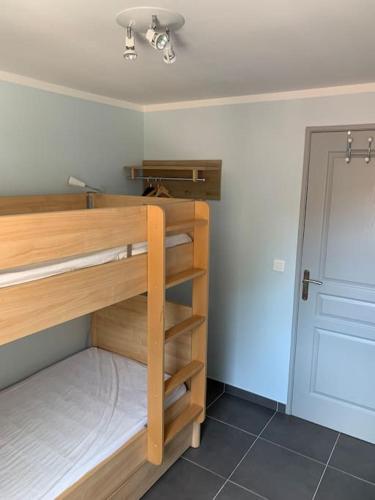 Cette chambre dispose de lits superposés en bois et d'une porte. dans l'établissement Maison Corallo splendide vue mer, à Porto-Vecchio