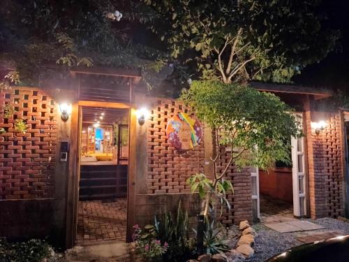 a house with a brick wall at night at Maloca Hospedagem in Sao Jorge