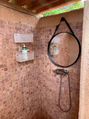 La salle de bains est pourvue d'une douche et d'un miroir rond. dans l'établissement Maison Corallo splendide vue mer, à Porto-Vecchio