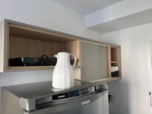 a white vase sitting on top of a kitchen appliance at studio 1104 Teresa WBE · Studio/sp/prox Allianz Parque/Puc/espaço américas in Sao Paulo