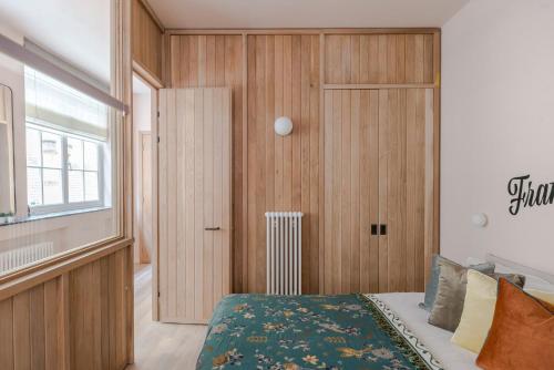 une chambre avec un lit et un mur en bois dans l'établissement Soho Swank - by Frankie Says, à Londres