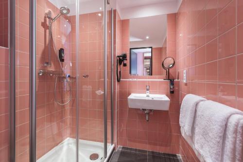 a bathroom with a shower and a sink at Holiday Inn - the niu, Loco Munich North by IHG in Munich