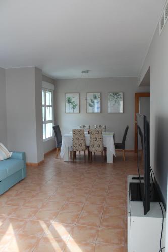 - un salon avec une table à manger et une télévision dans l'établissement Apto en Cullera con terraza, piscina, parking y wifi gratis, à Cullera