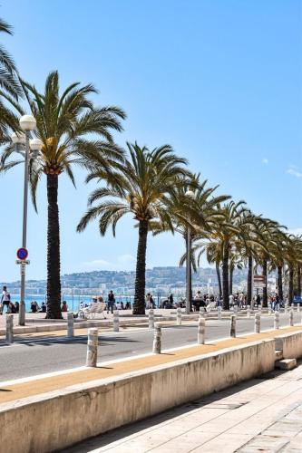 une rangée de palmiers sur un trottoir à côté de la plage dans l'établissement Suite Chic & Cosy, Hyper Centre, Proximité Plage, NICE CENTRE, à Nice