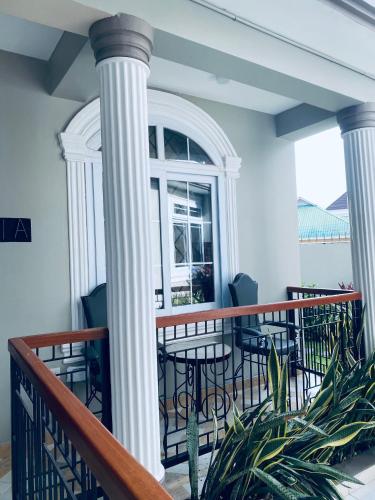 a porch with white columns and chairs and a window at Jacomo Residences in Dar es Salaam