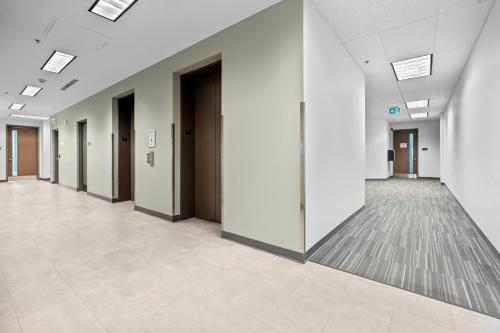 an empty hallway of an office building with doors at Bright Suites Finch West steps to Metro in Toronto