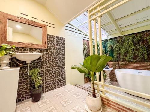 a bathroom with a tub and a sink and plants at Baan Bua Cottage SHA EXTRA PLUS B5510 in Ko Kood