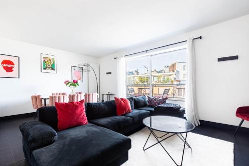 - un salon avec un canapé noir et une table en verre dans l'établissement GuestReady - View of the Eiffel Tower ideal for 2, à Paris