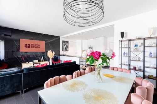 une salle à manger avec une table blanche et des chaises roses dans l'établissement GuestReady - View of the Eiffel Tower ideal for 2, à Paris