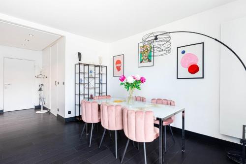 une salle à manger avec une table et des chaises roses dans l'établissement GuestReady - View of the Eiffel Tower ideal for 2, à Paris
