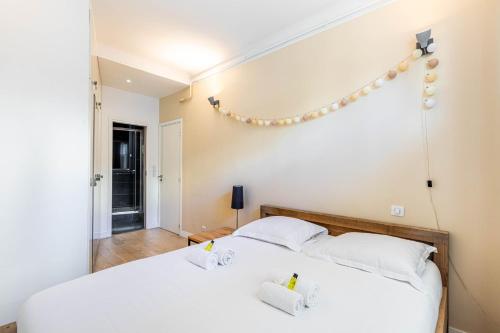 - une chambre avec un lit blanc et des lumières sur le mur dans l'établissement GuestReady - Peaceful haven perfect for 2, à Paris