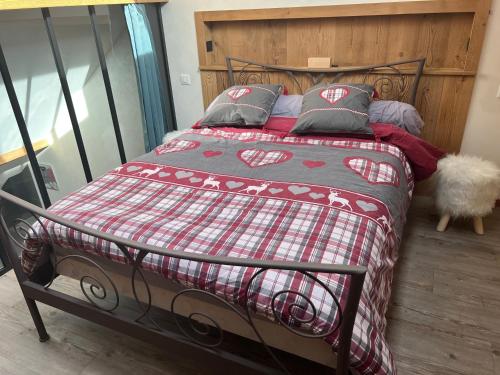 - un lit avec une couverture et des oreillers rouges et blancs dans l'établissement la vallée des marmottes, à La Bresse
