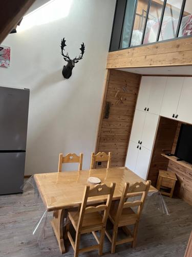 une salle à manger avec une table et des chaises en bois dans l'établissement la vallée des marmottes, à La Bresse