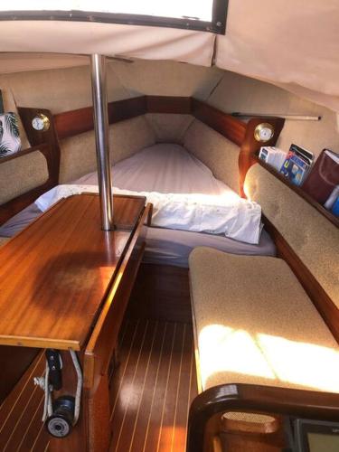 a small room with a bed and a desk at Bateau Jeanneau fantasia 8m à louer in La Rochelle