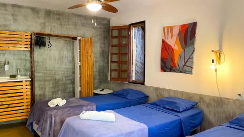 a room with two beds and a sink in it at Maloca Hospedagem in Sao Jorge