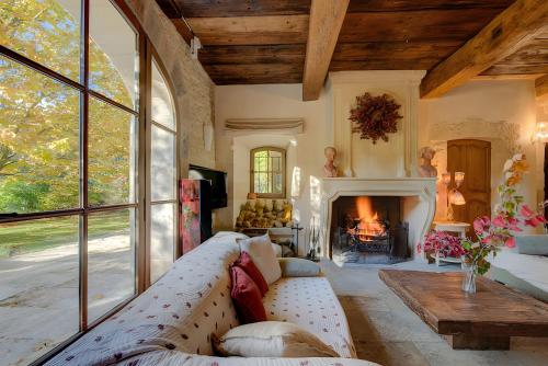 a living room with a couch and a fireplace at Mas Des Cigales et Roulotte Lambesc in Lambesc