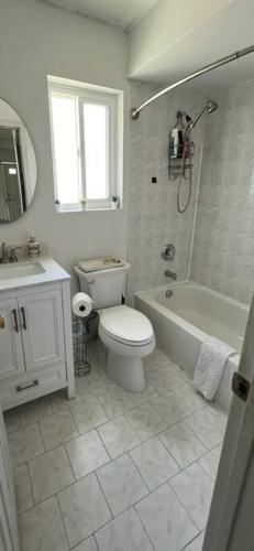 a bathroom with a toilet and a tub and a sink at Private BR,BA,KIT, LR 9 Mins to Beach in Edgemere