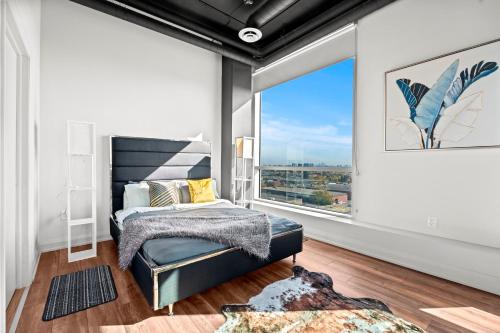 a bedroom with a bed and a large window at Bright Suites Finch West steps to Metro in Toronto