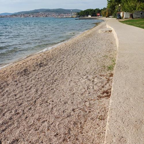 a sandy beach next to a body of water at Vila Matias in Vodice