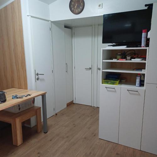 a room with white cabinets and a table and a tv at Vila Matias in Vodice