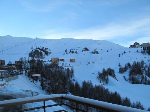 une montagne enneigée avec une station de ski au loin dans l'établissement Appartement moderne à Plagne Centre avec balcon, 2 chambres et Wifi - FR-1-351-93, à La Plagne