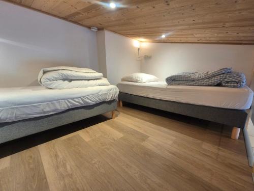 Cette chambre comprend 2 lits jumeaux et du parquet. dans l'établissement Tignes Val Claret - Studio pour 4 avec Mezzanine, WiFi et Casier à Skis - FR-1-502-582, à Tignes