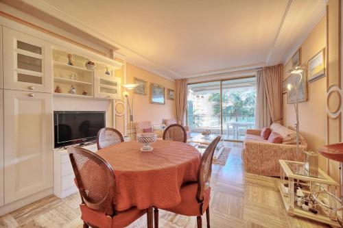 une salle à manger avec une table et un salon dans l'établissement REF 1908 - Cannes Croisette - Apartment for rent, à Cannes