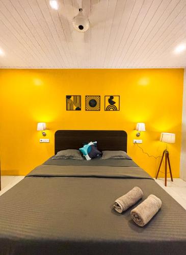 a bedroom with a large bed with yellow walls at Traverse Luxe Hostel Palolem in Palolem
