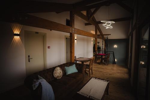 ein Wohnzimmer mit Sofa und Tisch in der Unterkunft Pensiunea Subcarpati in Jiblea Veche