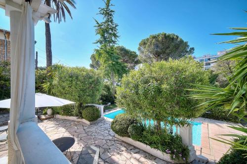- une piscine dans un complexe avec des arbres et des buissons dans l'établissement REF 1821 - Cannes Near Center - Villa for rent, à Cannes