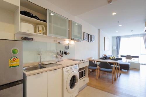 a kitchen with a sink and a washing machine at The Astra Condo City Center Chiang Mai-Apartment rental in Chiang Mai