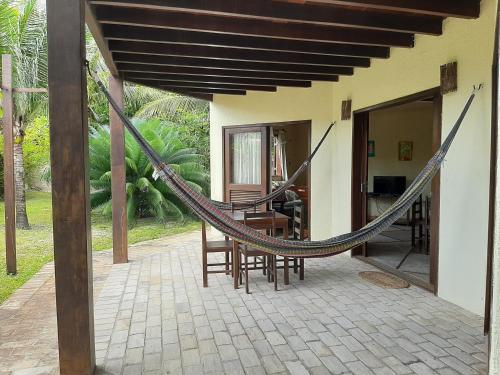 a hammock outside of a house with a patio at Casa na linda praia de Jericoacoara in Jericoacoara