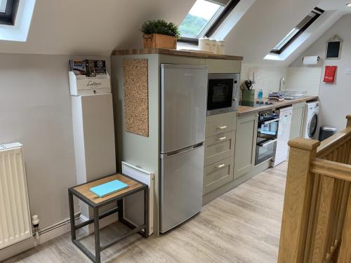 a kitchen with a refrigerator and a sink at Bakers Cottage in Ironbridge
