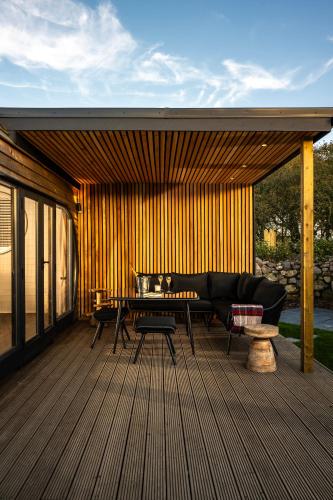 a patio with a couch and a table on a deck at Carbis Bay and Spa Hotel in St Ives