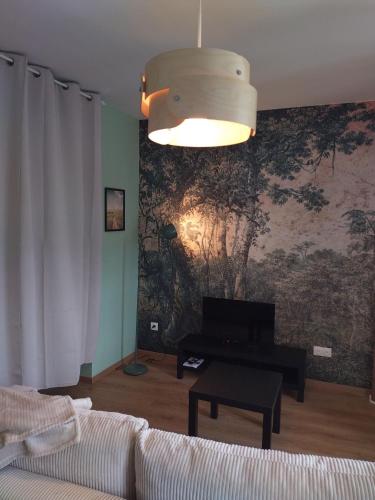 un salon avec un canapé et un tableau au mur dans l'établissement Appartement neuf, tout confort, à Issoire