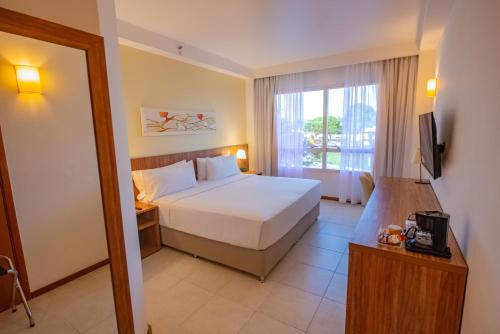 a hotel room with a bed and a window at Holiday Inn Manaus by IHG in Manaus