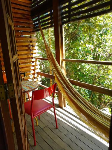 a hammock on the front porch of a house at Maloca Hospedagem in Sao Jorge