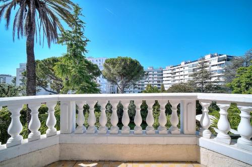 un balcon blanc avec un palmier en arrière-plan dans l'établissement REF 1821 - Cannes Near Center - Villa for rent, à Cannes