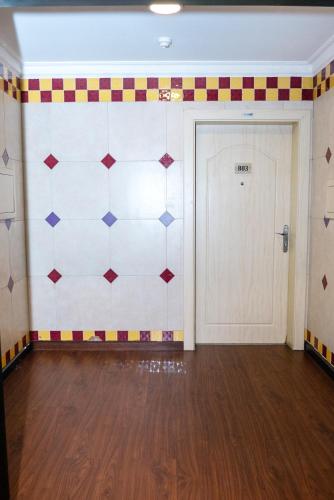 a room with a tiled wall with a door at Desert Pearl Hotel Apartment in Manama