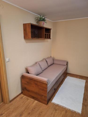 a couch in a room with a plant on the wall at Vila Pohoda Javorníky s rozľahlým pozemkom in Makov