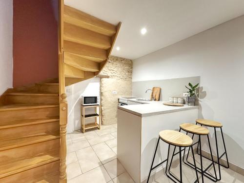 une cuisine avec un comptoir et des tabourets dans une pièce dans l'établissement Appart cosy au cœur du Vexin, à Oinville-sur-Montcient