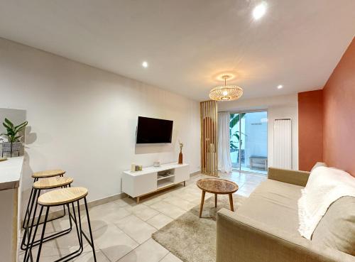 a living room with a couch and a tv at Appart cosy au cœur du Vexin in Oinville-sur-Montcient